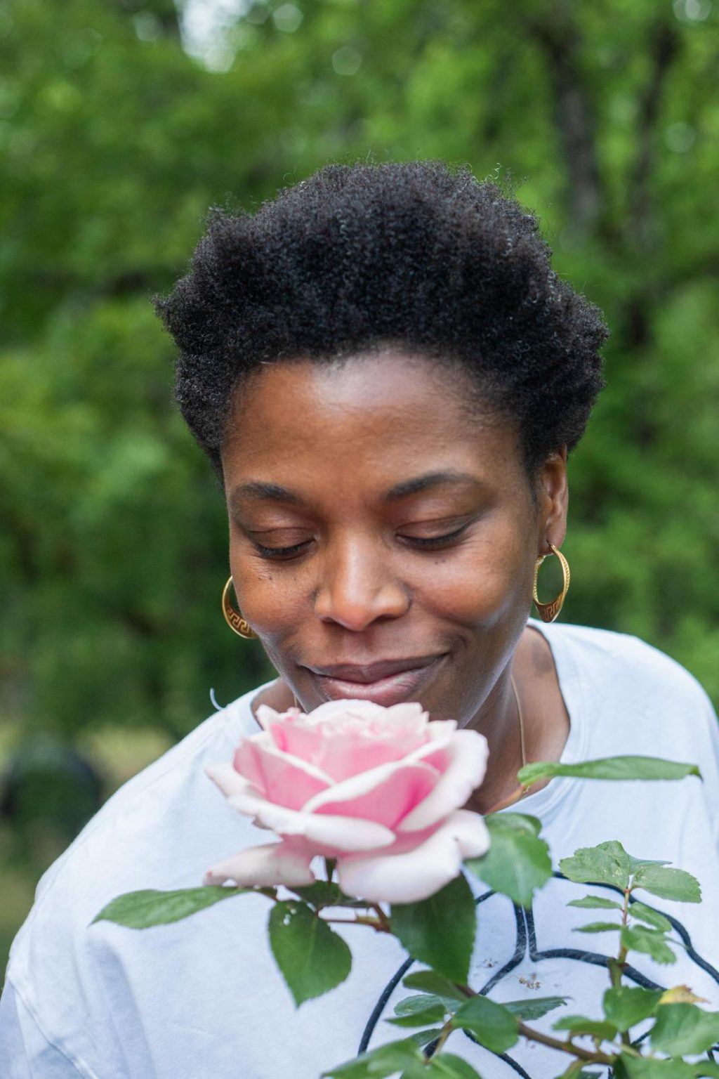 Latré Lawson respire une rose au jardin